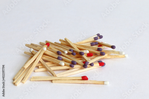Colorful matches are scattered on a white background