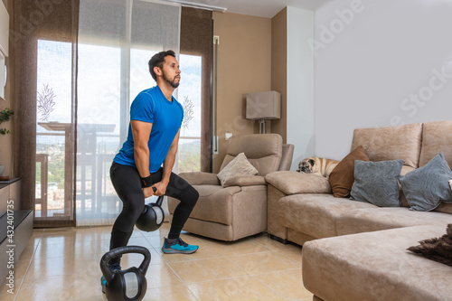 Latin man performing a cross fit workout at home