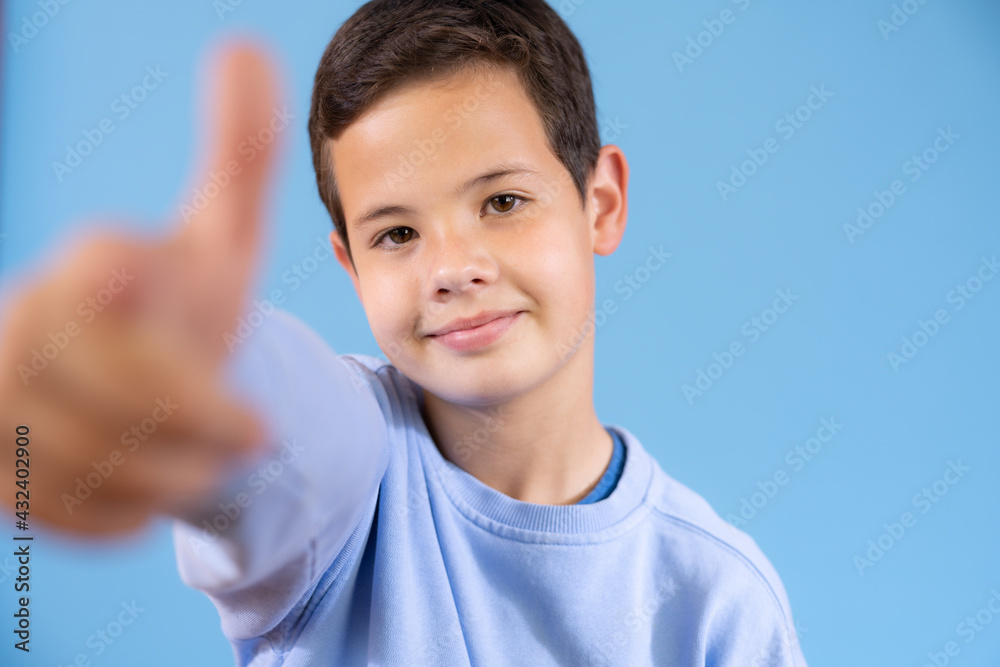 Like! Portrait of happy little boy in blue sweater smiling at camera and doing thumbs up gesture, showing agree cool approval sign. indoor studio shot isolated on blue background Like! Portrait of happy little boy in blue sweater smiling at camera and doing thumbs up gesture, showing agree cool approval sign. indoor studio shot isolated on blue background