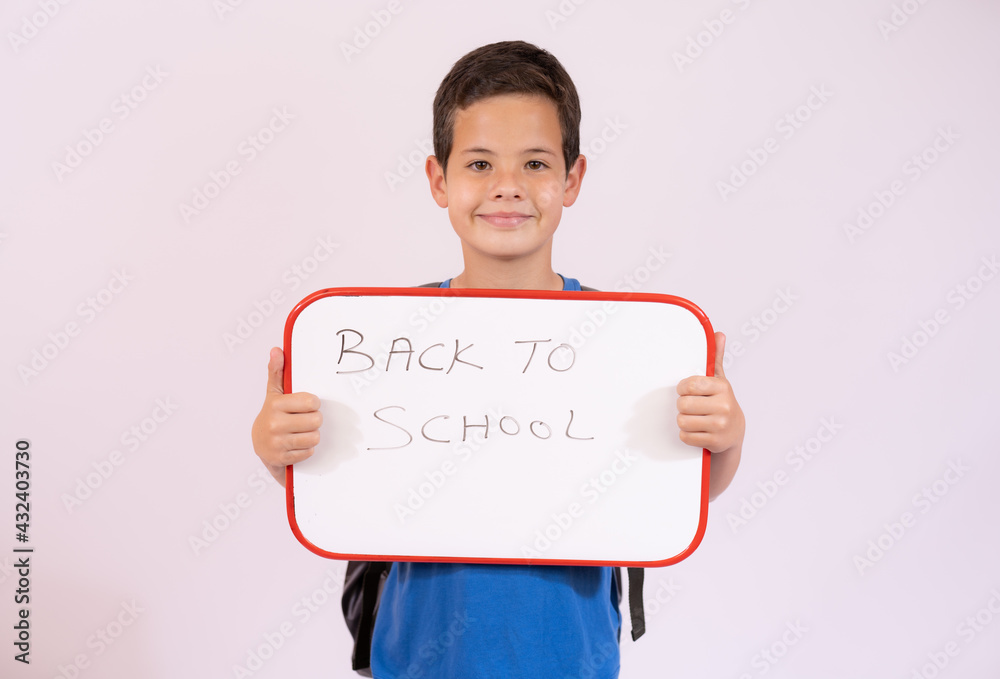 Beautiful young boy smiling holding a white board over white background ...