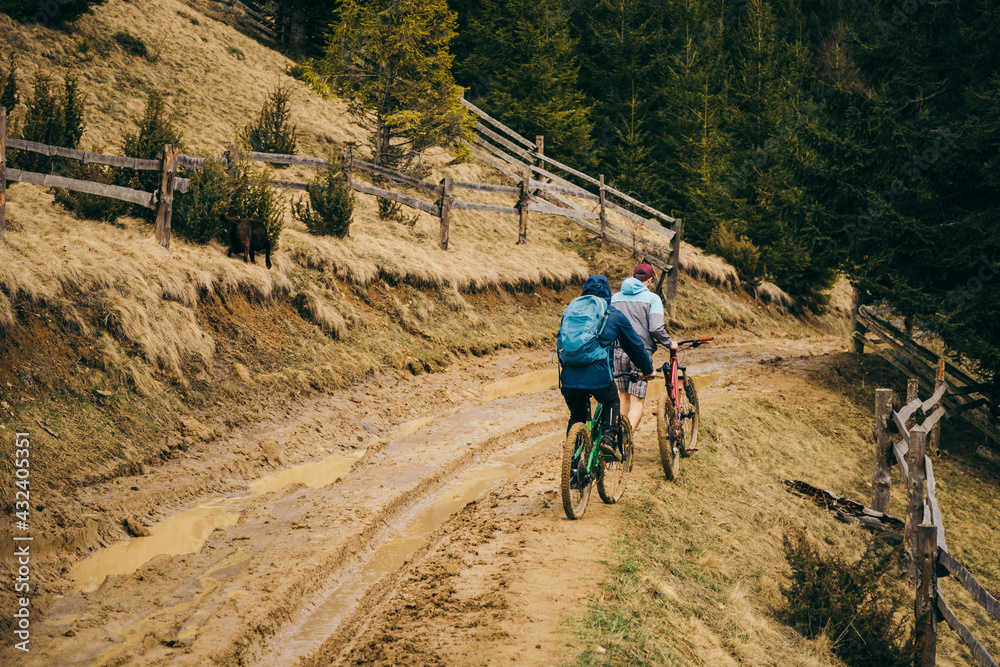 Fototapeta premium A man riding a bike down a dirt road