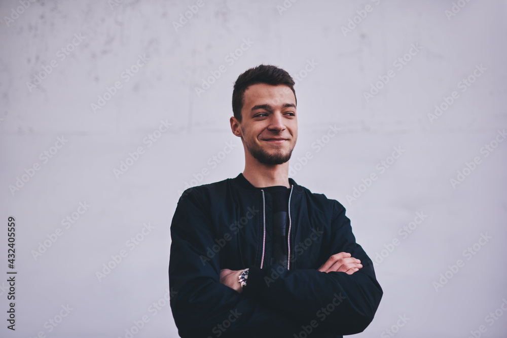 Smiling man folding hands near white wall Smiling man folding hands near white wall