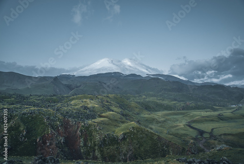 Fotografie Natural landscape with a hilly valley and Mount Elbrus in the center of the frame