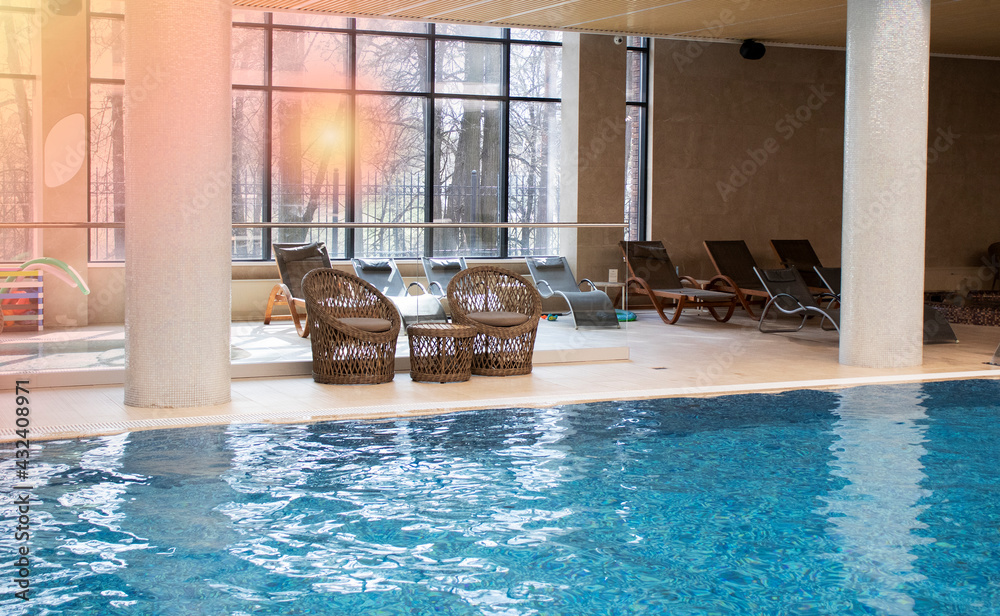 indoor pool with relaxation area - sun loungers and wicker chairs