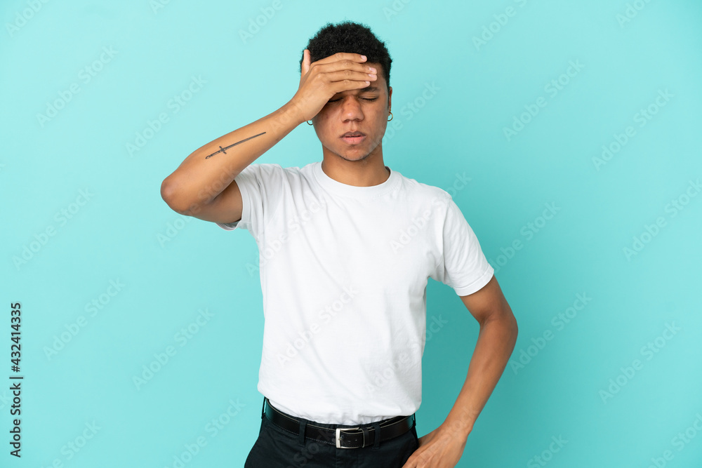Young African American man isolated on blue background with headache Young African American man isolated on blue background with headache