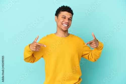 Young African American man isolated on blue background proud and self-satisfied photo