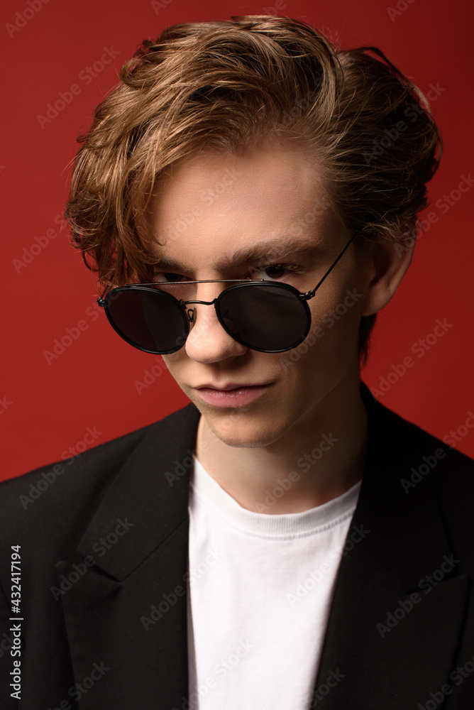 guy in black glasses, white t-shirt and black suit. beautiful, long blonde hair. serious facial expression guy in black glasses, white t-shirt and black suit. beautiful, long blonde hair. serious facial expression