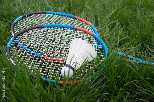 Badminton racket and ball on grass
