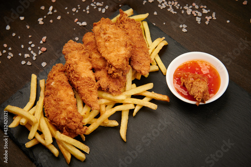 French fries with strips and red hot sauce with insert