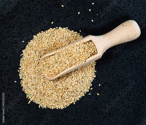 top view of scoop on foxtail millet seeds on black photo