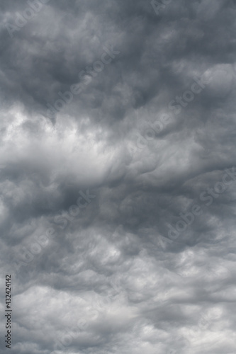 Moody sky with cloudscape forming mysterious shapes. A gray overcast day is enlightened by soft shapes in the cloud deck