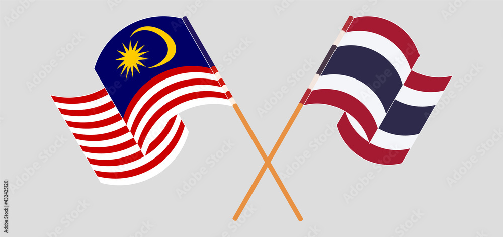 Crossed and waving flags of Malaysia and Thailand