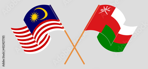 Crossed and waving flags of Malaysia and Oman