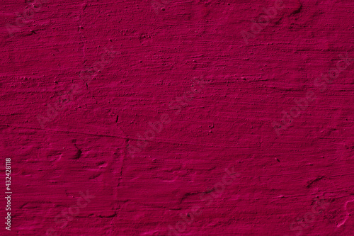 Texture of the dark pink stucco wall with scratches, cracks, dust, crevices, roughness. Can be used as a poster or background for design.