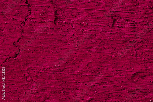Texture of the dark pink stucco wall with scratches, cracks, dust, crevices, roughness. Can be used as a poster or background for design.