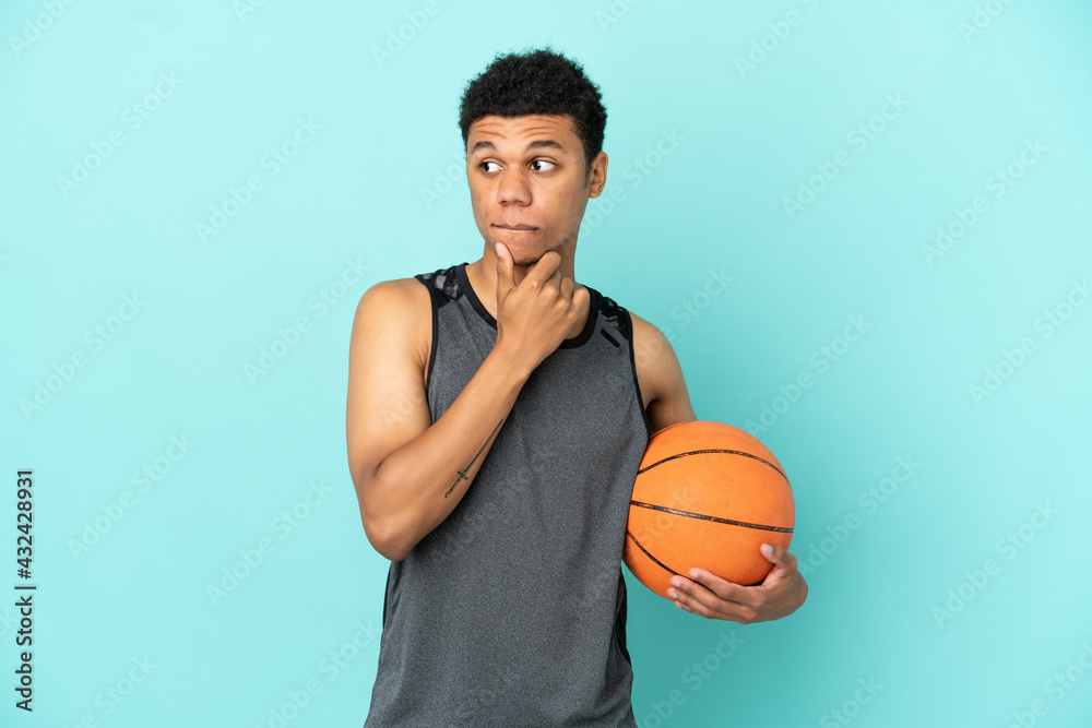 Basketball player African American man isolated on blue background having doubts and thinking