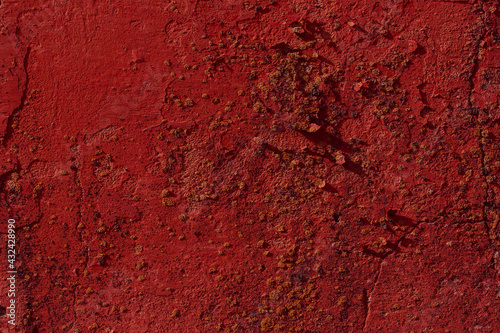 Red textured concrete wall with natural defects. Scratches, cracks, crevices, chips, dust, roughness. 