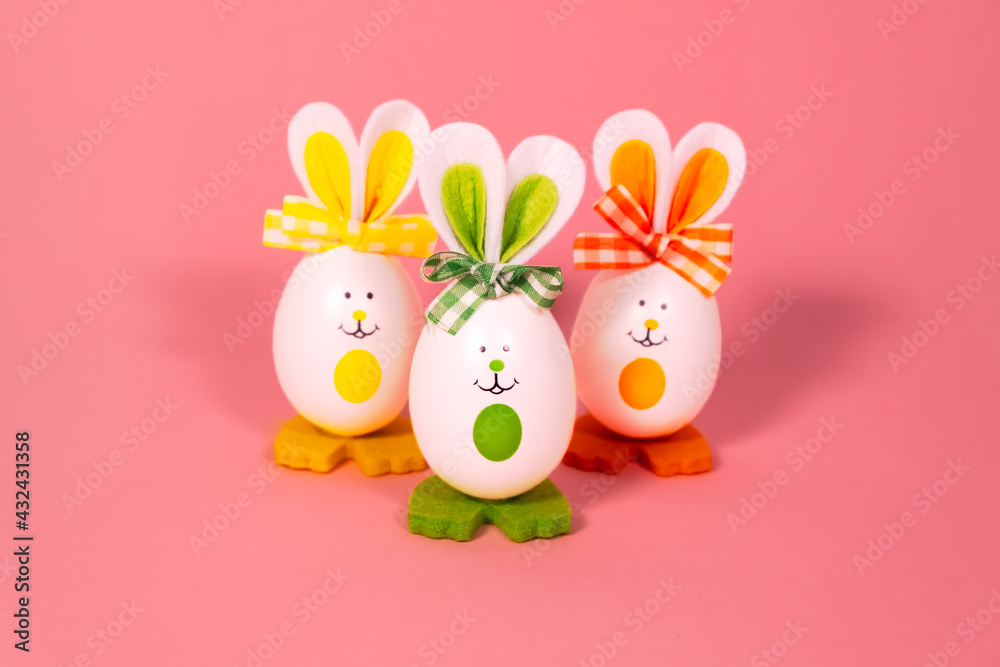 Obraz premium Ideas for holiday decoration. Easter eggs looking like a rabbit. With a painted face. On a light pink background. Copy space. Isolated
