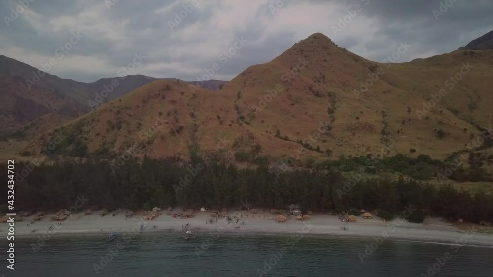 Aerial Shot Of Sea Against Mountain Range During Sunset, Drone Descending Over Ocean - Nagsasa Cove, Philippines Aerial Shot Of Sea Against Mountain Range During Sunset, Drone Descending Over Ocean - Nagsasa Cove, Philippines