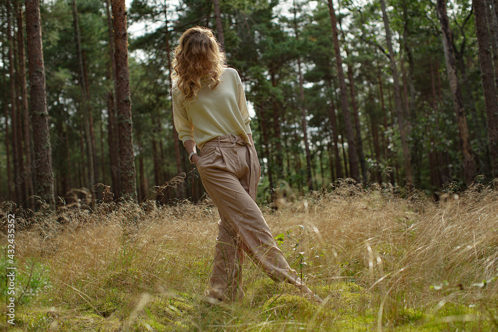 Beautiful women model relaxing in nature, forest. Long blond hair and stylish cozy clothes Beautiful women model relaxing in nature, forest. Long blond hair and stylish cozy clothes
