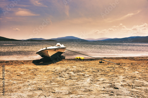 a small boat standing alone on the beach and the sky