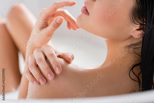 cropped view of young woman enjoying milk bath.