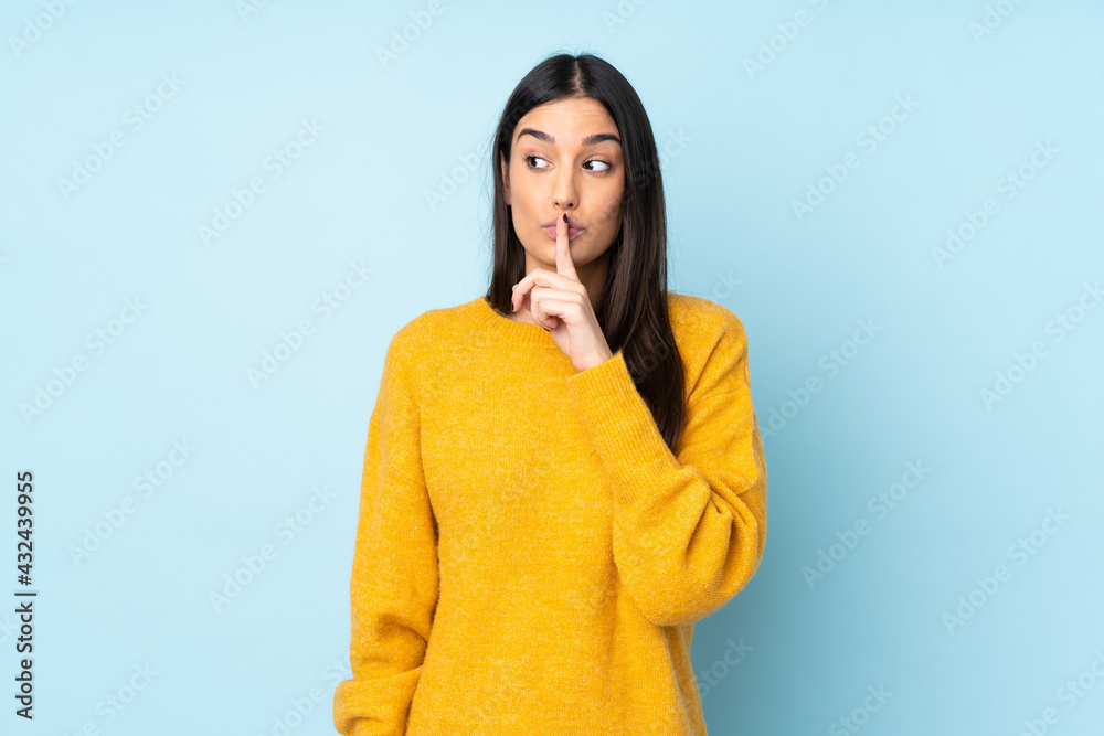 Young caucasian woman isolated on blue background showing a sign of silence gesture putting finger in mouth Young caucasian woman isolated on blue background showing a sign of silence gesture putting finger in mouth