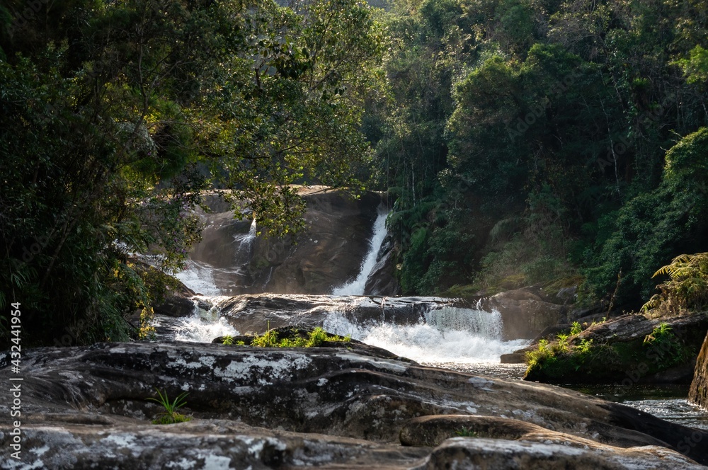 Obraz premium Distant shot of strong clear water current of Barracao waterfall. This is one of many cascades of Paraibuna river that runs in the middle of Sea Ridge dense jungle in Cunha, Sao Paulo - Brazil.