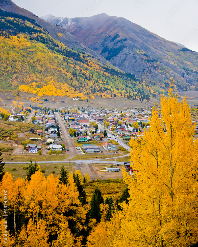 Obraz premium Silverton Colorado surrounded by gold and orange autumn leafed aspen trees on a foggy fall day in San Juan County, Colorado
