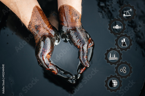 Crude oil in hand is an oil refining process. Folded cups of hands with fuel oil. photo