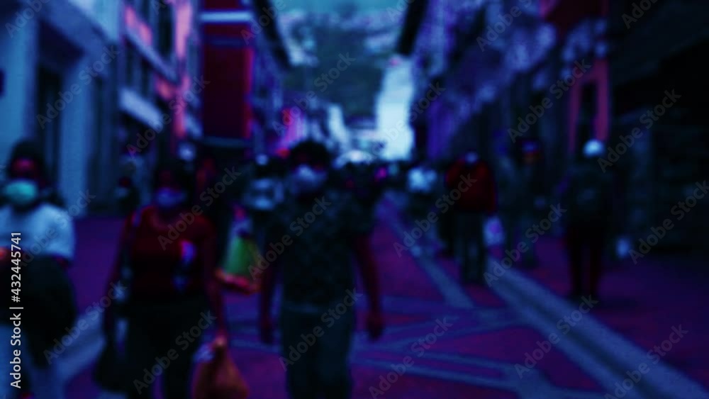 Neon light backview of commuters, street sellers and other people walking over a busy street in Quito, the capital of Ecuador, South America Neon light backview of commuters, street sellers and other people walking over a busy street in Quito, the capital of Ecuador, South America