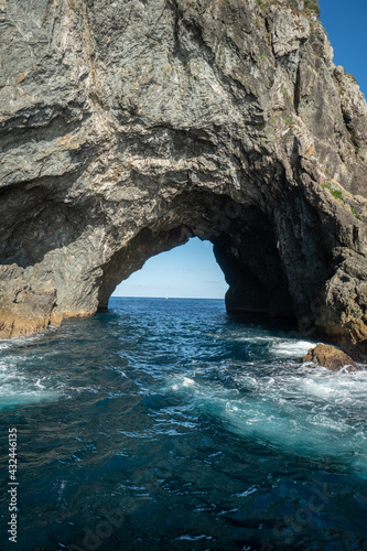 Cave in the Hole in the Rock with Boat in the distance In Bay Of Islands New Zealand