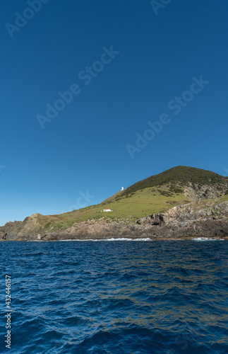 Cape Brett Lighthouse in the Distance Across the Water in the Bay of Islands New Zealand, with Copy Space