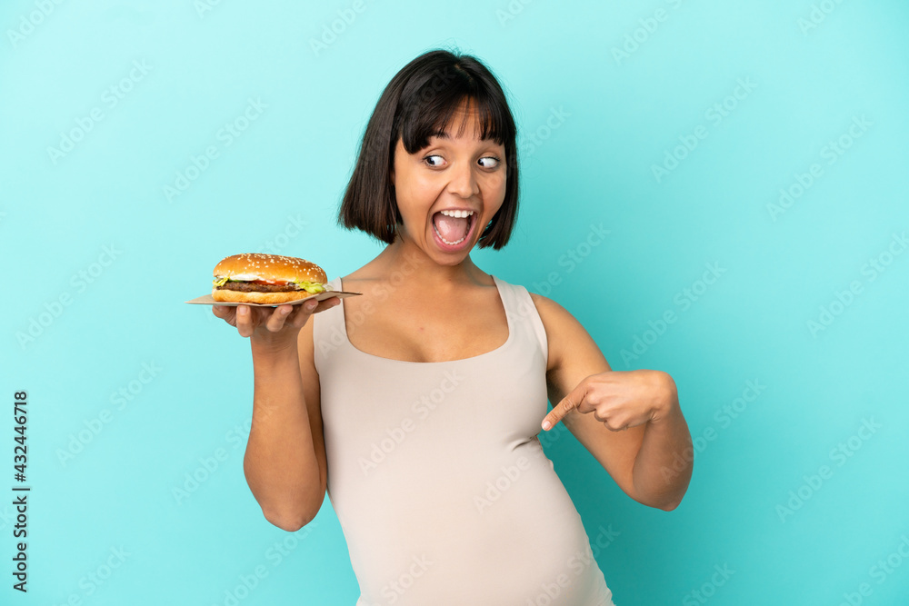 Young pregnant woman holding burge over isolated background