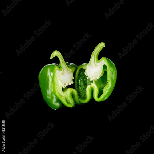 sliced ​​shiny green peppers on black background