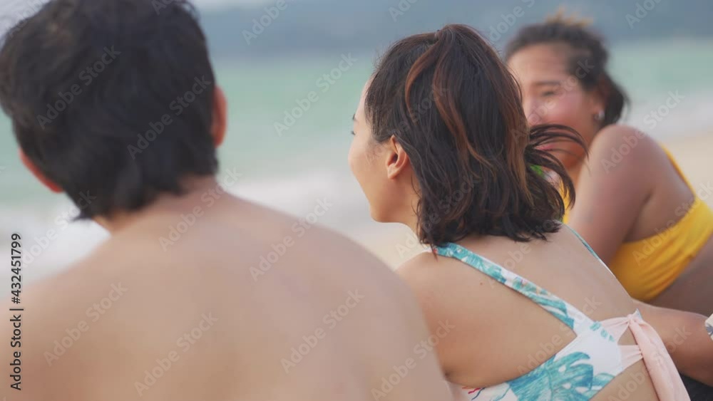 Group of Happy Asian man and woman friends sitting on the beach enjoy drinking beer with talking together at summer sunset. Male and female friendship relax and having fun outdoor lifestyle activity. Group of Happy Asian man and woman friends sitting on the beach enjoy drinking beer with talking together at summer sunset. Male and female friendship relax and having fun outdoor lifestyle activity.