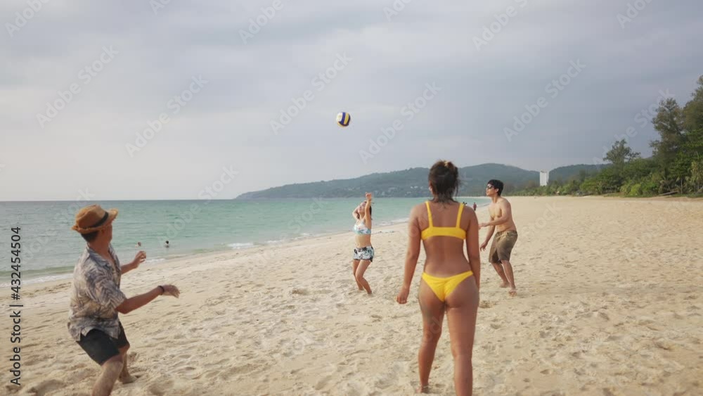 4K Group of Asian man and woman friends playing beach volleyball together on tropical beach in sunny day. Male and female friendship enjoy and having fun outdoor lifestyle activity on summer vacation 4K Group of Asian man and woman friends playing beach volleyball together on tropical beach in sunny day. Male and female friendship enjoy and having fun outdoor lifestyle activity on summer vacation