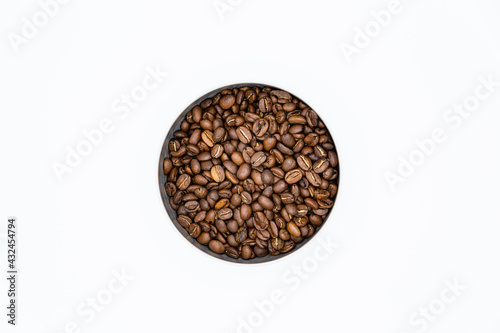 Mixture of different kinds of roasted coffee beans in white container on white background. Top view and copy space.