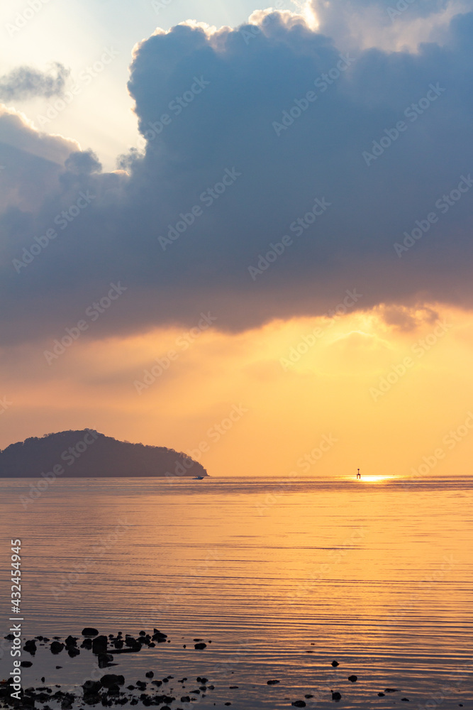 Amazing sunrise over the seashore, Beautiful cloudy sky and a golden beam light emanating from heaven