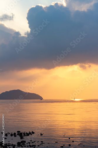 Amazing sunrise over the seashore, Beautiful cloudy sky and a golden beam light emanating from heaven