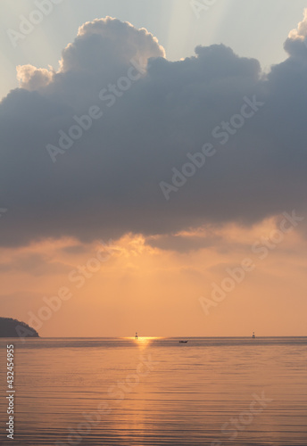Amazing sunrise over the seashore, Beautiful cloudy sky and a golden beam light emanating from heaven