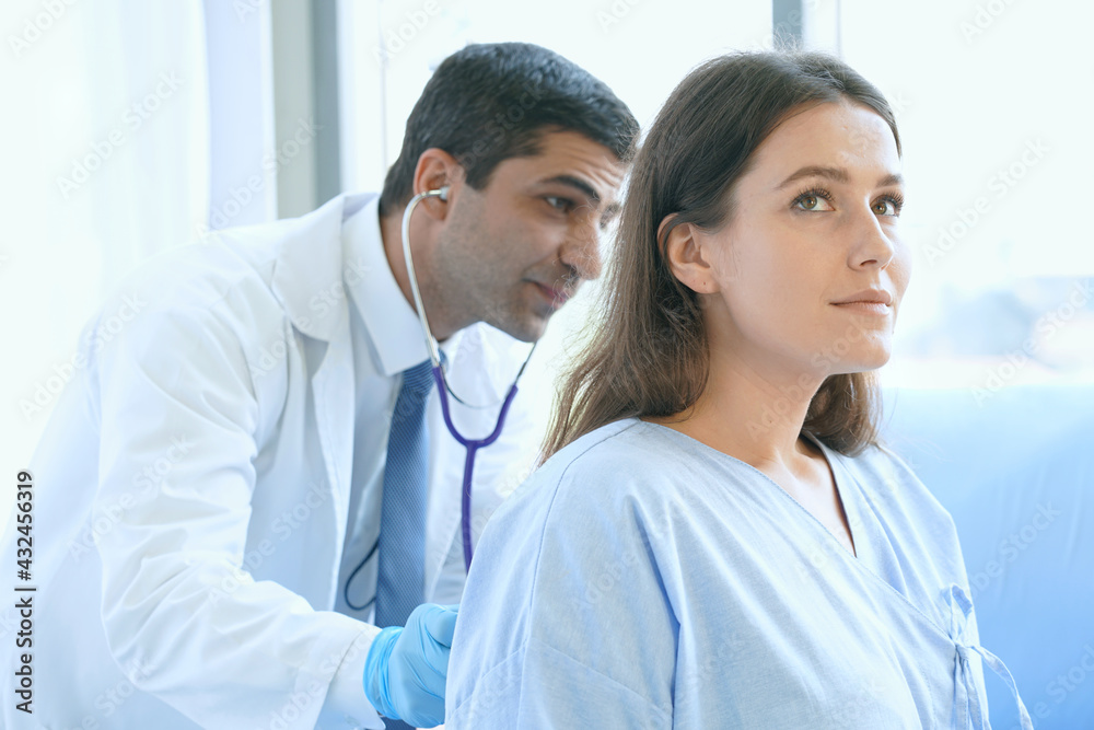 Doctor uses a stethoscope to check the heart beat with the woman patient in the hospital or the doctor examines the heart. Doctor uses a stethoscope to check the heart beat with the woman patient in the hospital or the doctor examines the heart.