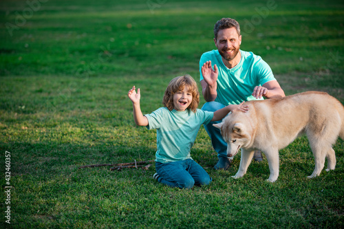 Happy father and son with dog at park. Weekend activity happy family lifestyle concept.