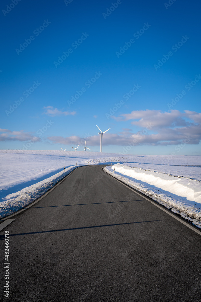 Road in winter landscape with beautiful blue sky 