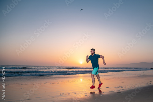 Runner man on the beach be running for exercise. Active healthy runner jogging outdoor. Young man training on the beach in morning.