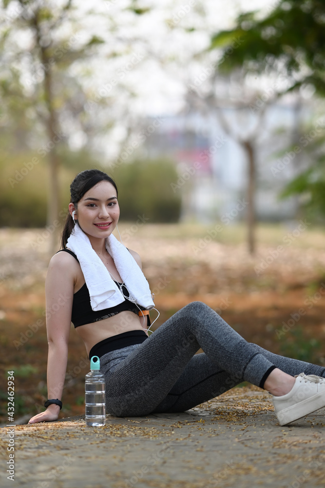 Happy sportswoman taking a break in nature park after outdoor workout. Happy sportswoman taking a break in nature park after outdoor workout.