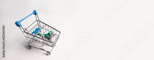 Vaccine bottle in trolley cart for import coronavirus (COVID-19) vaccine on banner white background. Purchasing vaccine covid-19 concept.