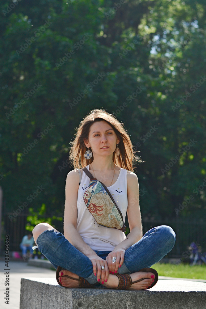 Beautiful happy girl practicing yoga in lotus position in the park in the morning. Beautiful happy girl practicing yoga in lotus position in the park in the morning.
