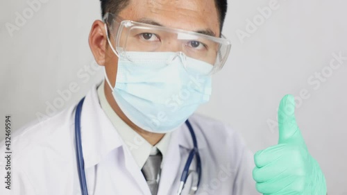 A male doctor wore a mask and looked at the camera with his hand raised, like, and nodded with a feeling of encouragement and hope.