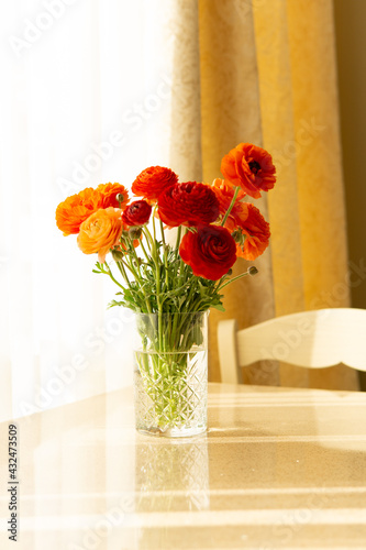 A bouquet of bright red flowers in a vase on the table.